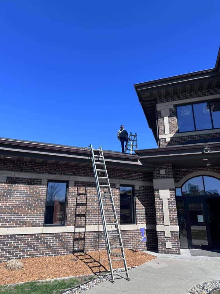 A man on the roof with a gutter